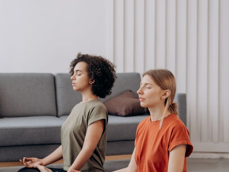 A person practicing yoga in a calm, minimalist room with soft light.